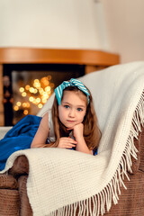 Little girl by the fireplace waiting for Christmas