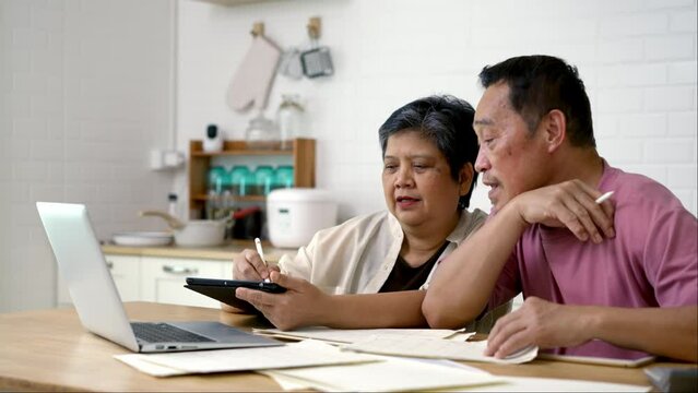 Happy Asian Senior Couple Use Digital Technology Device To Working At Home