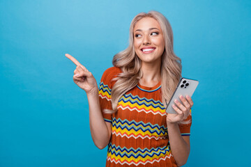 Photo of dreamy pretty girl dressed print shirt typing apple iphone samsung device pointing empty space isolated blue color background