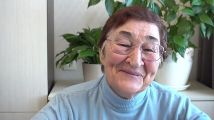 A cheerful elderly woman smiles widely at the camera. Ideal for content about older people, positive aging and active aging.