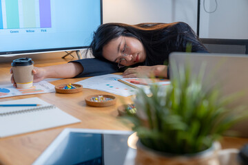 A tired young woman feeling exhausted from heavy work, accidentally dozing off at the office.