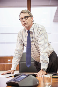 Manager level employee of business start-up standing at his desk looking into the distance. Cape Town, South Africa