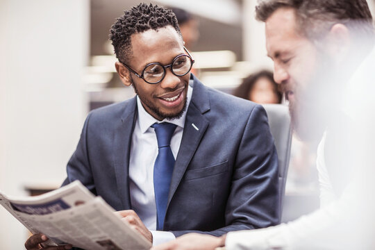 Colleagues with diverse backgrounds working, talking and hanging out in large office space. Cape Town, South Africa