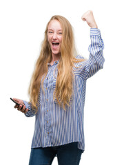 Obraz premium Blonde teenager woman using smartphone annoyed and frustrated shouting with anger, crazy and yelling with raised hand, anger concept