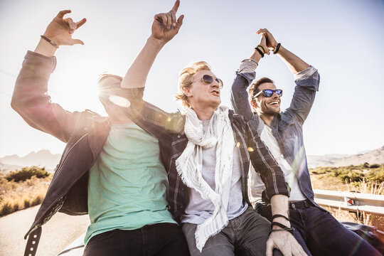 Group of friends driving around and having fun in the South African countryside in a vintage convertible. Paarl, South Africa