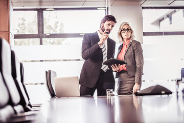Two business colleagues are brainstorming together in the lounge at their office.
