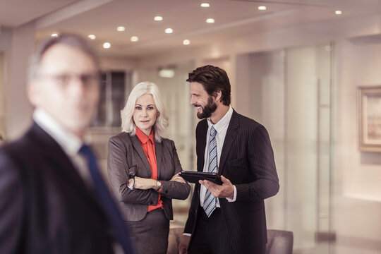 Three business colleagues are brainstorming together in the lounge at their office.