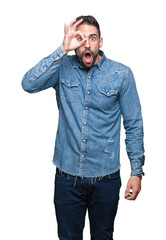 Young handsome man over isolated background doing ok gesture shocked with surprised face, eye looking through fingers. Unbelieving expression.