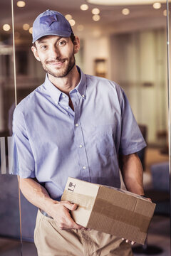 Package delivery person picking up package at large office building.