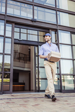 Package delivery person picking up package at large office building.