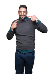 Young handsome man wearing glasses over isolated background smiling confident showing and pointing with fingers teeth and mouth. Health concept.
