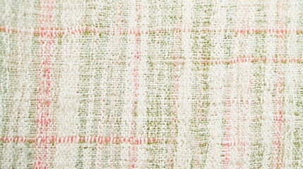 Close-up of weaved, tweed style fabric in pastel colors for spring backdrops. Warp, weft threads in pink, green, pale brown, light yellow color. Celebrate spring, nice weather with unique fabrics.
