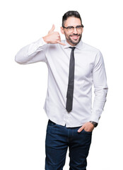 Young handsome business man wearing glasses over isolated background smiling doing phone gesture with hand and fingers like talking on the telephone. Communicating concepts.