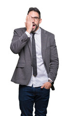 Young handsome business man over isolated background covering one eye with hand with confident smile on face and surprise emotion.