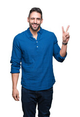 Young handsome man over isolated background smiling with happy face winking at the camera doing victory sign. Number two.