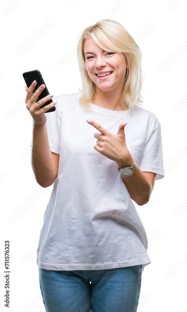 Wall mural Young beautiful blonde woman using smartphone over isolated background very happy pointing with hand and finger