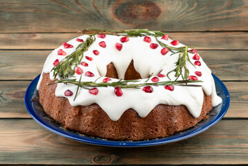 Close-up of a cupcake with rosemary frosting, buttercream and pomegranate seeds.