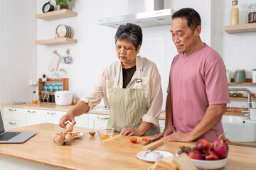 Mature asian Couples enjoy to cooking meal together in kitchen.