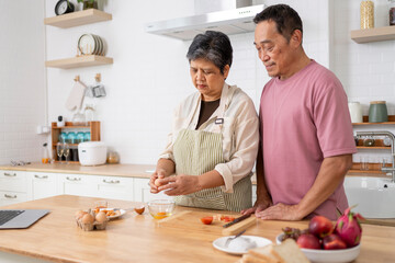 Mature asian Couples enjoy to cooking meal together in kitchen.