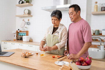 Mature asian Couples enjoy to cooking meal together in kitchen.