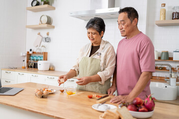 Mature asian Couples enjoy to cooking meal together in kitchen.