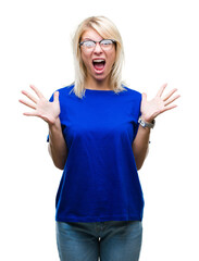 Young beautiful blonde woman wearing glasses over isolated background celebrating crazy and amazed for success with arms raised and open eyes screaming excited. Winner concept