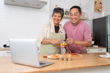 Mature asian Couples enjoy to cooking meal together in kitchen.