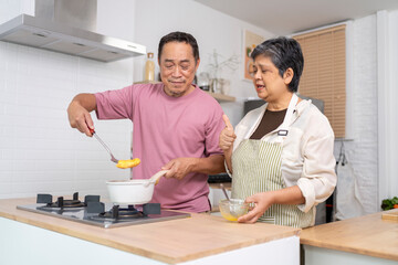 Mature asian Couples enjoy to cooking meal together in kitchen.
