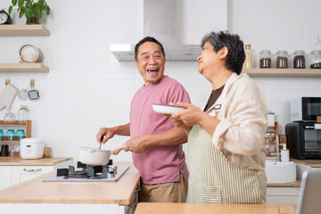 Fototapeta premium Mature asian Couples enjoy to cooking meal together in kitchen.