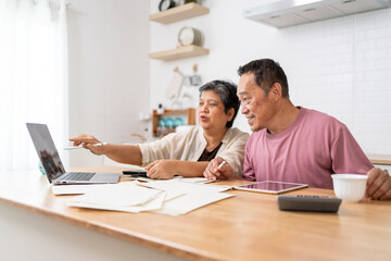 Obraz premium Happy Asian senior couple use digital technology device to working at home
