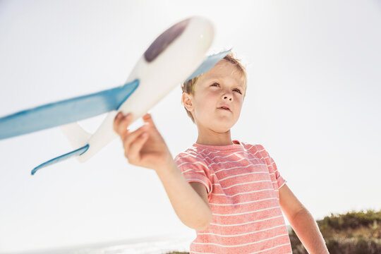 Young boy playing with and flying his model airplane