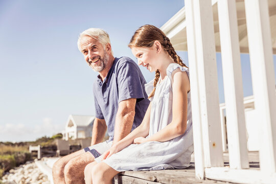 Mann mit Enkelin am Strandhaus bei Sonnenuntergang, Kapstadt, S&uuml;dafrika 
