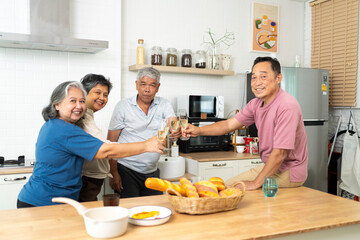Group of Happy Asian senior drinking wine to celebrate while dining together