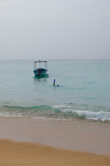 Person in fins dived under the water, a leg in a fin sticks out of the water