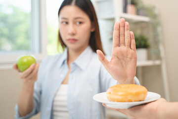 Diet food loss weight concept, Hand of woman pushing sweet away and avoid to eat fried chicken to control cholesterol and sugar.