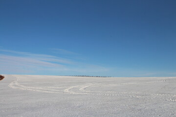 A large flat plain with blue sky and clouds