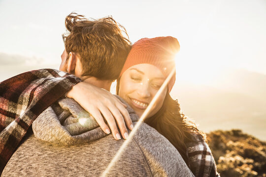Romantic couple hugging in the mountains at sunset