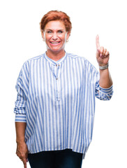 Naklejka premium Atrractive senior caucasian redhead woman over isolated background showing and pointing up with finger number one while smiling confident and happy.