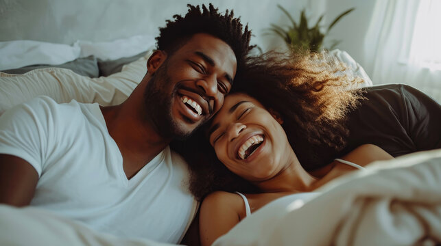 Interracial couple, laughing and relaxing on bed for morning bonding, funny relationship or joke at home.