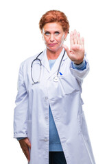 Senior caucasian doctor woman wearing medical uniform over isolated background doing stop sing with palm of the hand. Warning expression with negative and serious gesture on the face.