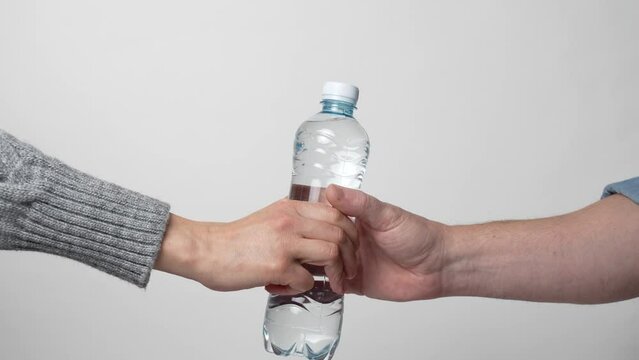 Hand Giving Bottle Of Water To Another Person, Close-up