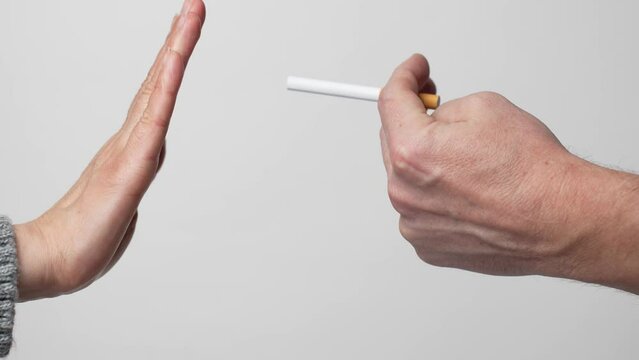 Hand giving a cigarette to another hand, close-up