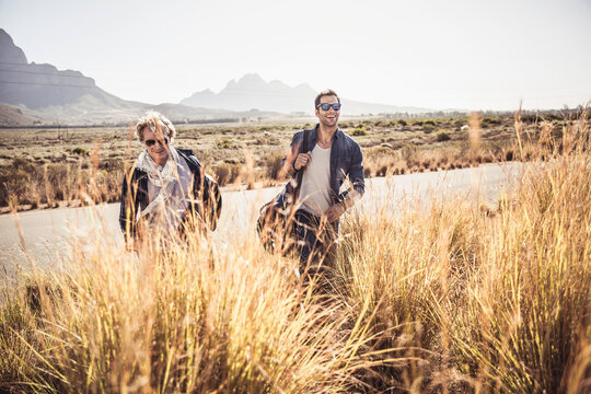 Group of guys walking along a road while hitch hiking.