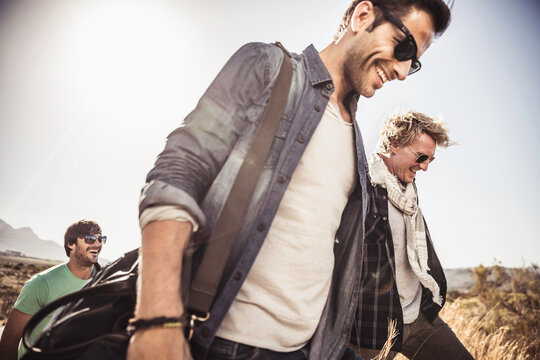 Group of guys walking along a road while hitch hiking.