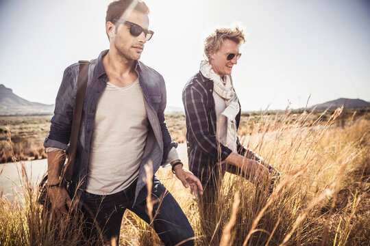 Group of guys walking along a road while hitch hiking.