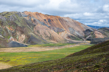 The picturesque Icelandic landscape of rainbow volcanic rhyolite mountains in cloudy weather on Icelandic highlands at Landmannalaugar, Iceland. Famous Laugavegur hiking trail. Iceland in august.