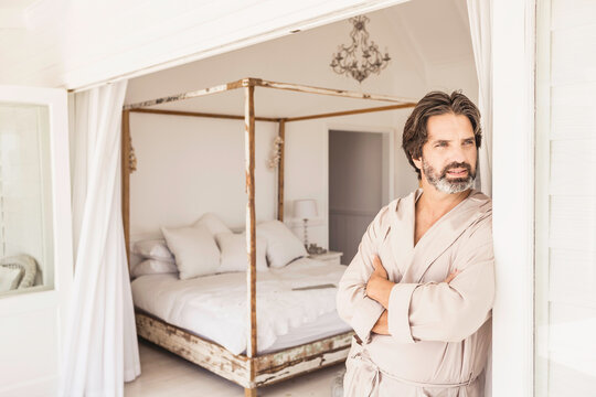Man enjoying morning coffee in a bath robe at a beach house