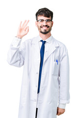 Young professional scientist man wearing white coat over isolated background smiling positive doing ok sign with hand and fingers. Successful expression.