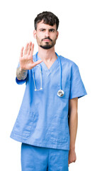 Young handsome nurse man wearing surgeon uniform over isolated background doing stop sing with palm of the hand. Warning expression with negative and serious gesture on the face.