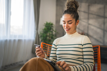 young woman caucasian female hold credit card online shopping at home